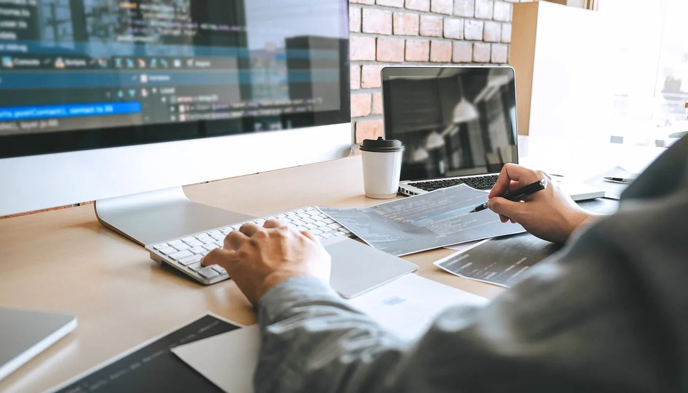 Hamilton web designer meeting with local business owners to review a new WordPress website on a laptop.